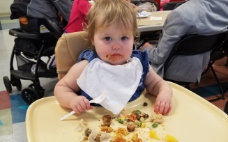 infant with tray full of food. 