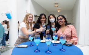 Four students cheers with their commemorative blue buffalo glasses at the Toast to 2022 senior send off. 