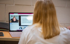 faculty member teaches remotely from laptop. 