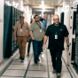 UBIT staff walking down a corridor of BullsAI servers. 