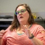 A security expert explains her strategy to a colleague beside an immortal office fern. 