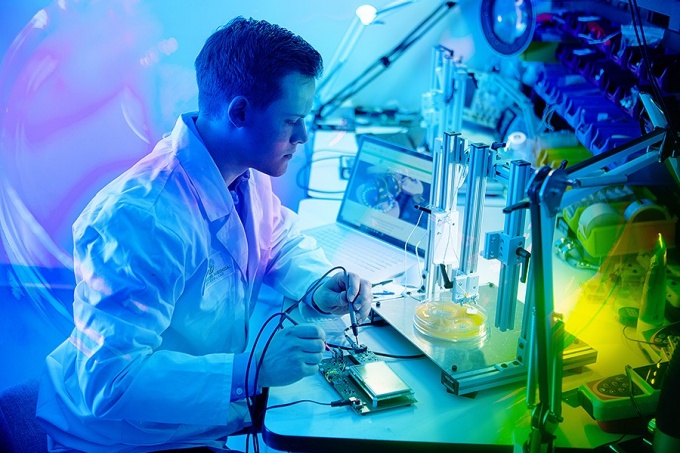 A researcher in a lab coat in a stylized image set in one of UB's research facilities. 