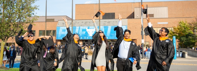 Students throw caps at commencement. 