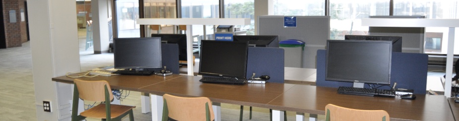 Research stations in a computing site are located near a Library Reference Desk and have a Research name tag attached. 