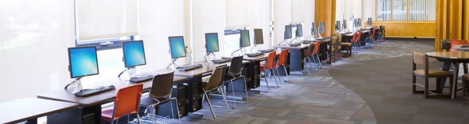 Clement Resdience Hall room 128 computers lined up on tables along windows. 