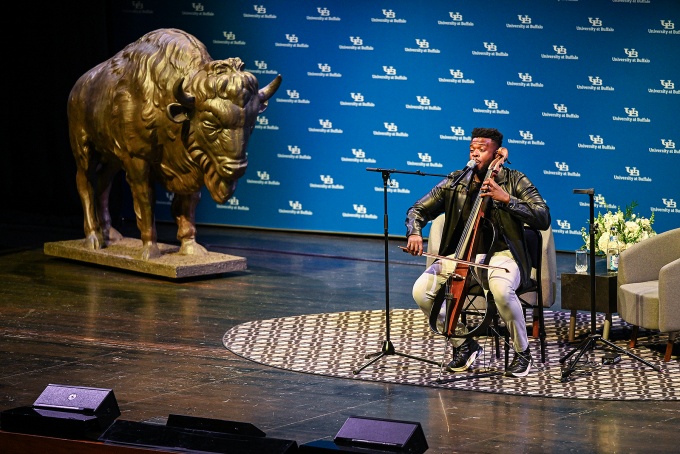 Kevin Olusola on the stage in the CFA Mainstage playing the cello. 