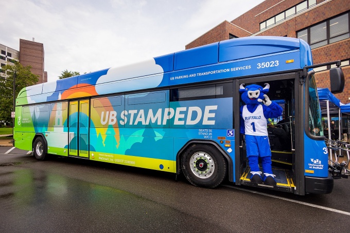 UB mascot Victor E. Bull stands on the steps entering one of eight new electric UB Stampede buses. 