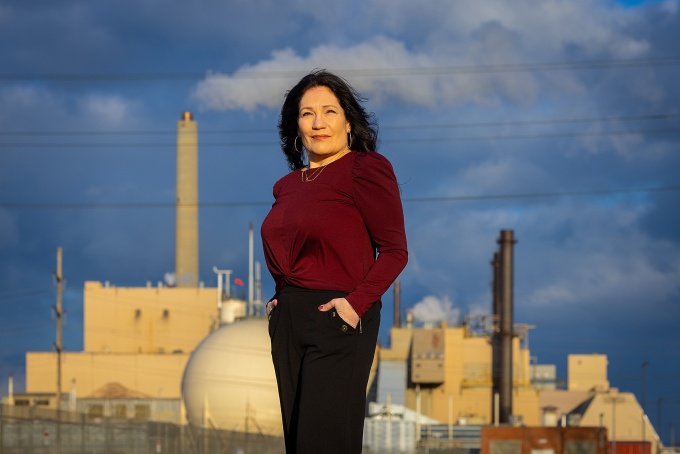 Christen Civiletto poses in front of chemical factories. 