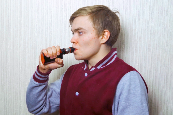A teen vaping. 