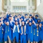 Students standing on stairs in caps and gowns. 