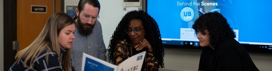 Marketing and Communications staff discuss projects in the office. 
