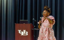 Dr. Alexandria White gives a speech next to a UB podium. 