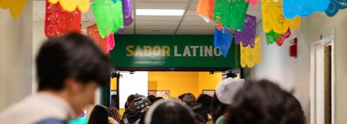Students photographed from behind at the Sabor Latino entrance. 