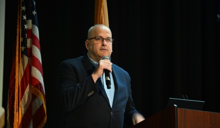 Brian Hamluk holding a microphone as he gives a speech. 