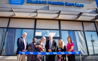 Zoom image: The UB community gathers for the grand opening of the Student Health Services center, located at 4350 Maple Road, near Sweet Home Road, in August 2022. Cutting the ribbon from left, Provost A. Scott Weber; Sharon Mitchell, senior director of student wellness; Susan Snyder, director, Student Health Services; Brian Hamluk, vice president for student life; Mary Stock, clinical assistant professor and senior physician; and Paula Taton, clinic manager. Photographer: Meredith Forrest Kulwicki
