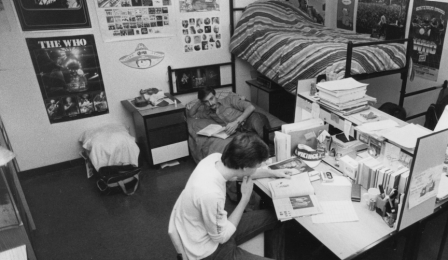 Old picture of UB students in dorm room with 1970s and 1980s rock posters.
