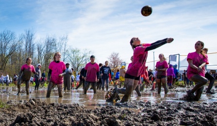 A team of 6 players, covered in mud, work together to win their match in the 2022 Oozefest Tournament. 