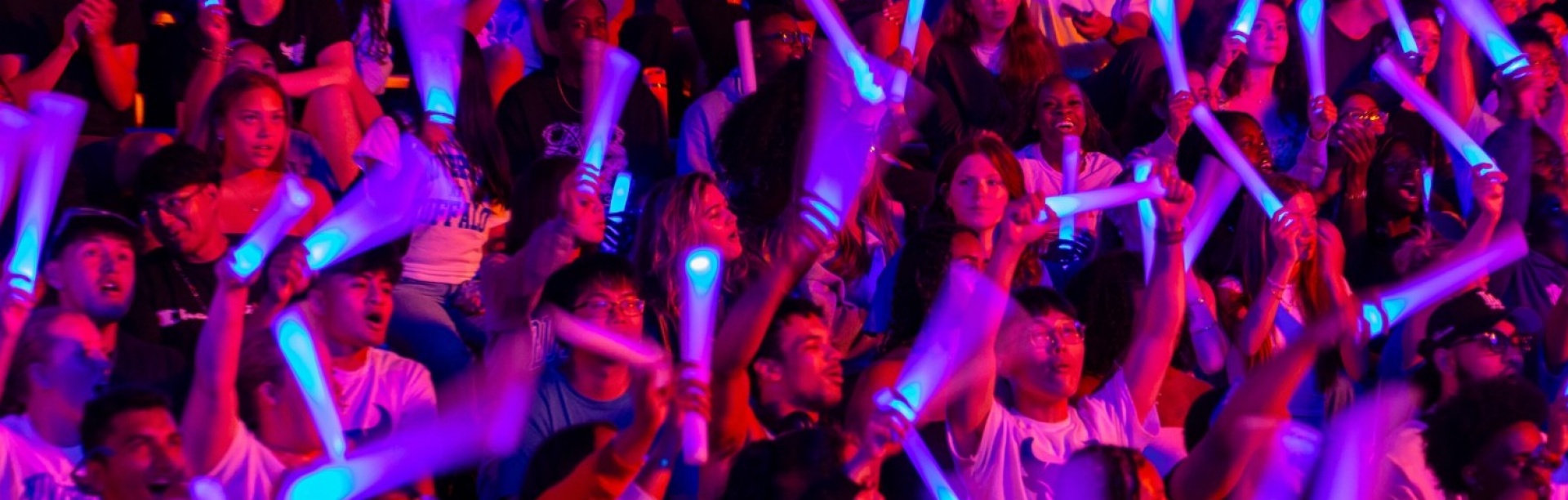 Students with their blue glow sticks in the stands at the Welcome Back Blast. 