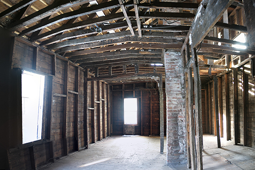 a large, gutted room with wooden beams exposed